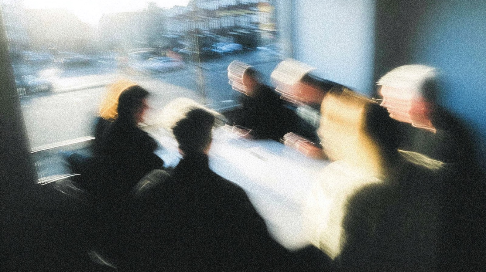 Editorial photograph with motion blur, two figures walking against twilight sky